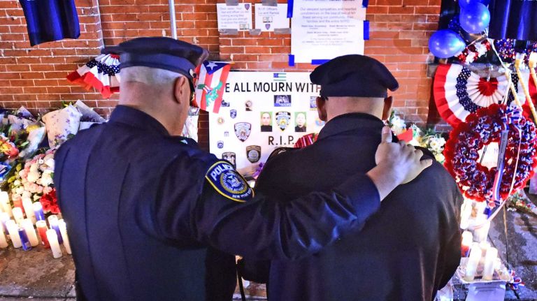 Police officers gather to mourn the loss of NYPD Officers Rafael Ramos and Wenjian Liu on Dec. 22, 2014 at a makeshift memorial set up at the scene of their killings in Brooklyn.