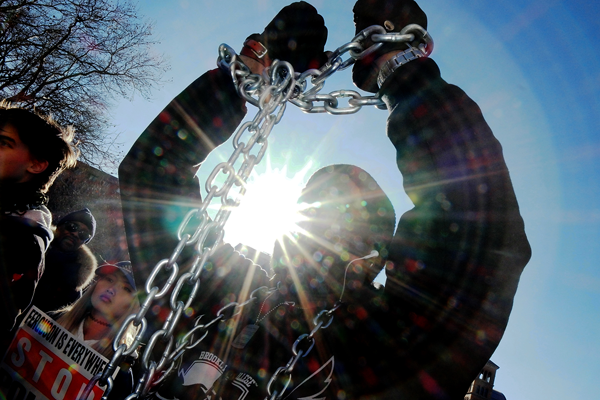 A marcher wore chains symbolizing America’s ongoing legacy of slavery and inequality at the start of Saturday’s mass protest.   Photo by Milo Hess