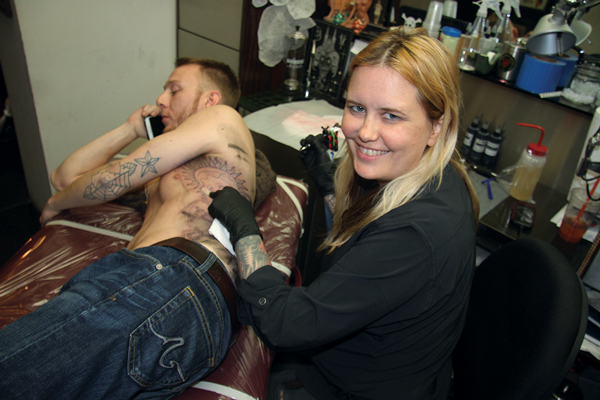 Michelle Myles doing the outline for a customer’s tattoo at Daredevil Tattoo.    Photo by Clayton Patterson
