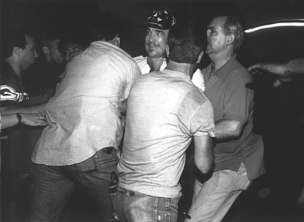 Clayton Patterson being swarmed and arrested by plainclothes police officers. For years after his infamous riot videotape, Patterson was a marked man as far as the police were concerned.   Photo by Q. Sakamaki