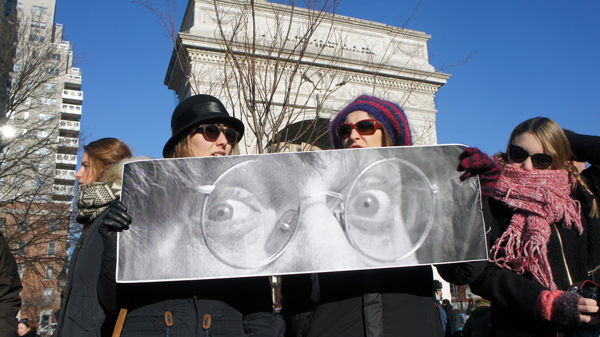 Women held a poster of the eyes of Jean Cabut, 76, a.k.a. “Cabu,” a staff cartoonist at Charlie Hebdo, who was targeted and killed in the Jan. 7 attack at the magazine’s Paris office.  Photo by Liza Bear