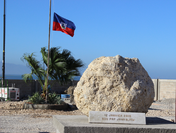The Haitian flag flew at half-mast by the boulder memorial, marking the mass grave where thousands of the earthquake’s victims are buried.