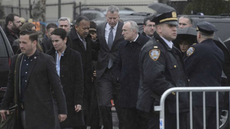 Police Commissioner William J. Bratton, right, Mayor Bill de Blasio, center, and NYPD First Deputy Commissioner Benjamin Tucker talk as they walk to the wake of Det. Wenjian Liu at Aievoli Funeral Home in Brooklyn on Saturday, Jan. 3, 2015. 