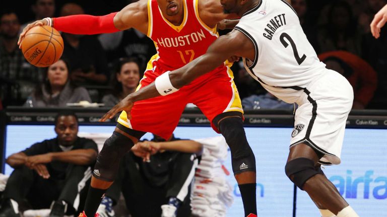 Dwight Howard #12 of the Houston Rockets controls the ball against Kevin Garnett #2 of the Brooklyn Nets during a game at Barclays Center on Monday, Jan. 12, 2015.