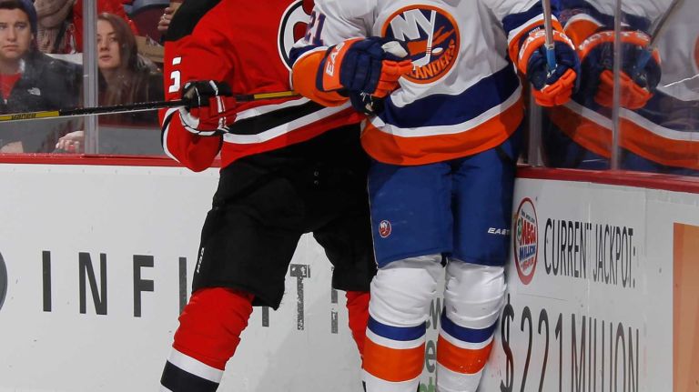 Adam Larsson of the New Jersey Devils hits Kyle Okposo of the New York Islanders into the boards during the first period at the Prudential Center on Jan. 9, 2015 in Newark, N.J.