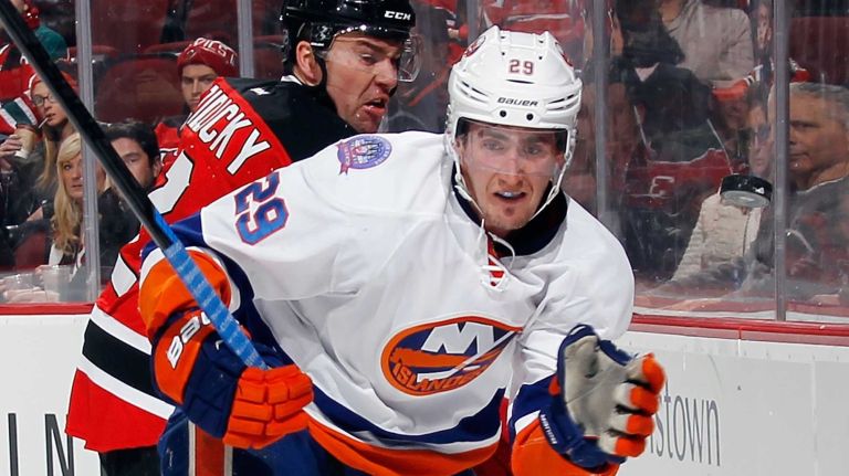 Brock Nelson of the New York Islanders flips the puck ahead of himself while being checked by Marek Zidlicky of the New Jersey Devils during the first period at the Prudential Center on Jan. 9, 2015 in Newark, N.J.