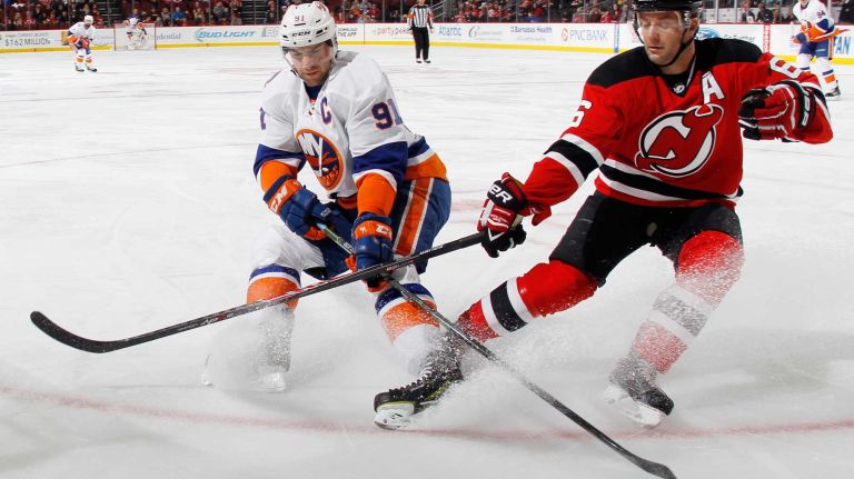 John Tavares of the New York Islanders and Andy Greene of the New Jersey Devils battle for the puck during the first period at the Prudential Center on Jan. 9, 2015 in Newark, N.J.