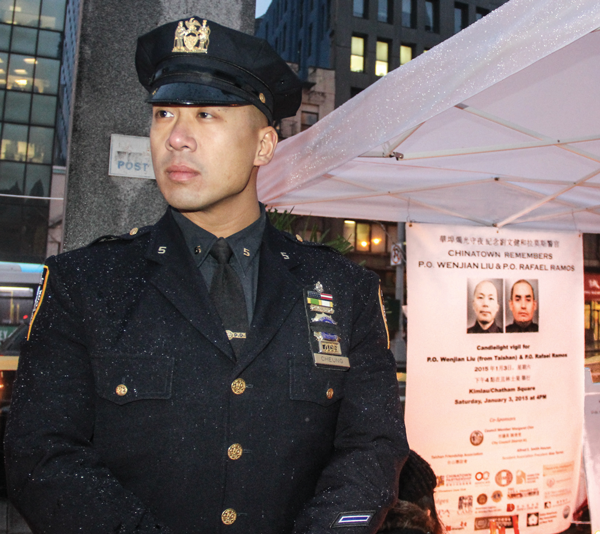 Chinatown mourns the city’s slain police officers 2 Downtown Express photos by Tequila Minsky. A Fifth Precinct police officer at the memorial. Many officers came by to light a candle and pay their respects.
