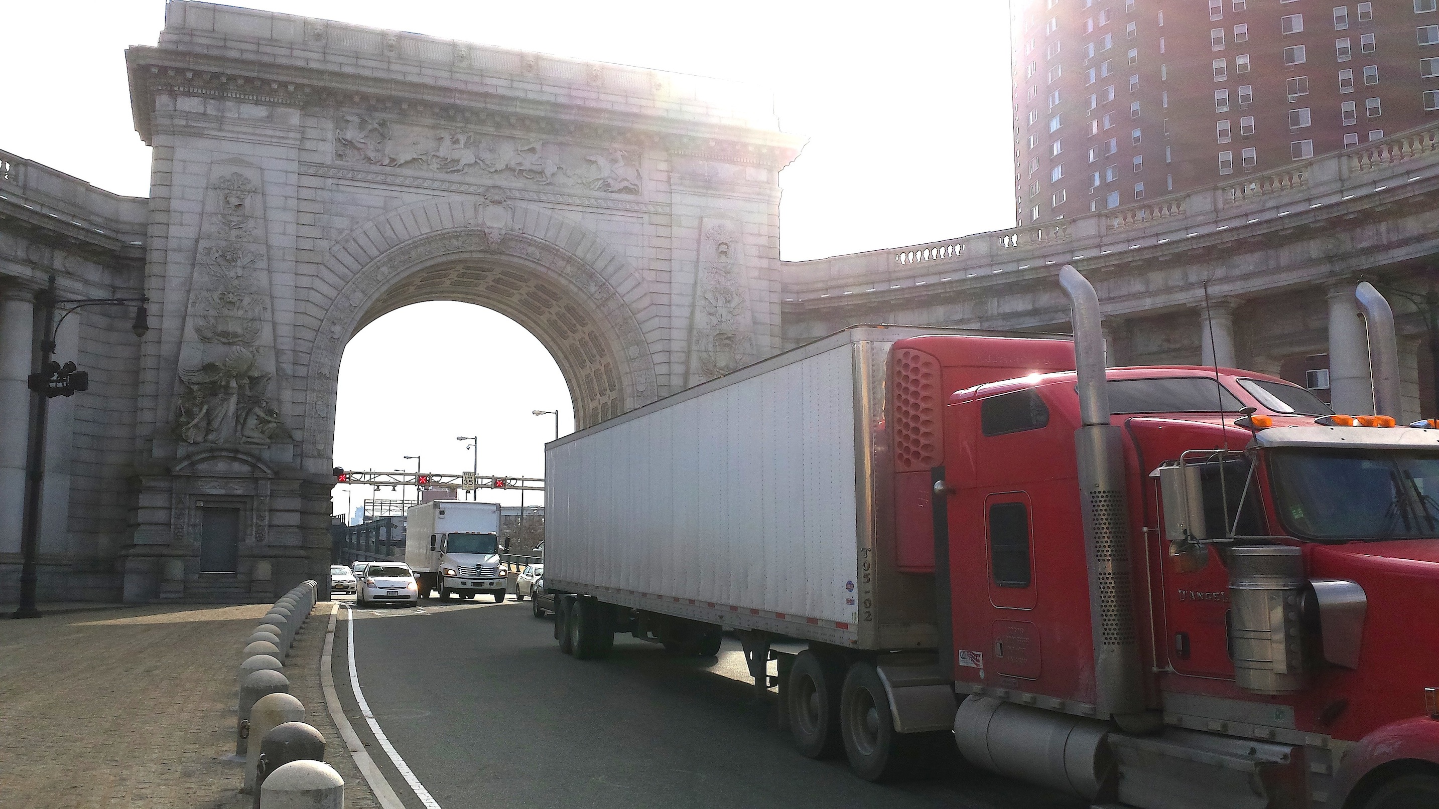 Traffic, including a five-axle tractor-trailer and other trucks, streams off the toll-free Manhattan Bridge and onto Canal St.  Photo by Lincoln Anderson
