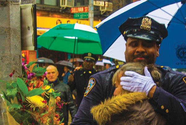 Iola Latman, the mother of slain Auxiliary Officer Nicholas Pekearo, got a warm hug from a police officer at Saturday’s memorial service. Photo by Zach Wiliams