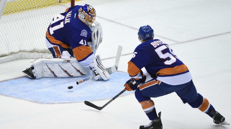 New York Islanders goalie Jaroslav Halak deflects the puck as New York Islanders defenseman Johnny Boychuk defends in the second period of an NHL hockey game at Nassau Coliseum on Thursday, March 26, 2015.