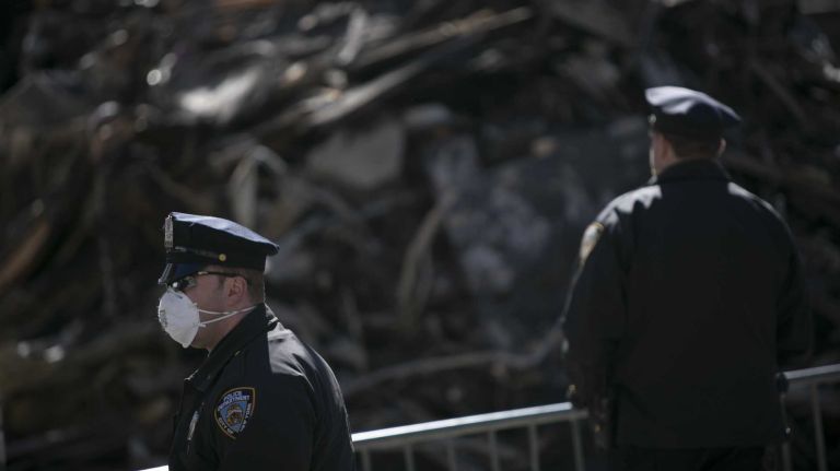 NYPD members stand near sight of a 7 Alarm fire and building collapse on 2nd Avenue in Manhattan, as seen on March 29, 2015.  