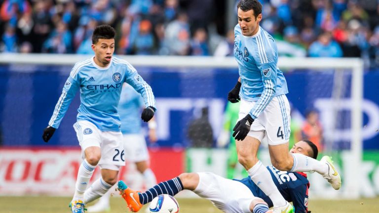 New York City FC midfielder Andrew Jacobson (4) avoids a slide tackle by New England Revolution midfielder Daigo Kobayashi (16) during a game at Yankee Stadium on Sunday, March 15, 2015.