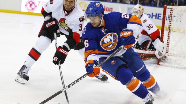 Tyler Kennedy of the New York Islanders plays the puck against Marc Methot of the Ottawa Senators at Nassau Coliseum on Friday, March 13, 2015.
