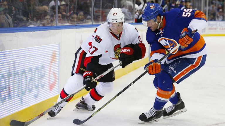 Johnny Boychuk of the New York Islanders defends against Curtis Lazar of the Ottawa Senators during the second period at Nassau Coliseum on Friday, March 13, 2015.