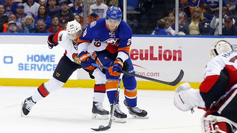 Erik Karlsson of the Ottawa Senators defends against Brock Nelson of the New York Islanders late in the third period at Nassau Coliseum on Friday, March 13, 2015.