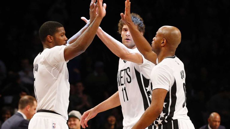 Joe Johnson of the Brooklyn Nets celebrates with teammates Brook Lopez and Jarrett Jack after hitting a three-point shot late in a game against the Indiana Pacers at Barclays Center on Tuesday, March 31, 2015.