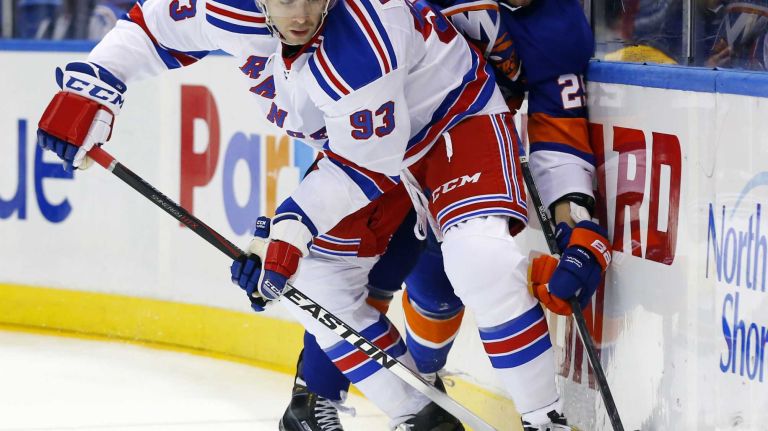 Keith Yandle of the New York Rangers plays the puck in the first period against Brock Nelson of the New York Islanders at Nassau Coliseum on Tuesday, March 10, 2015.