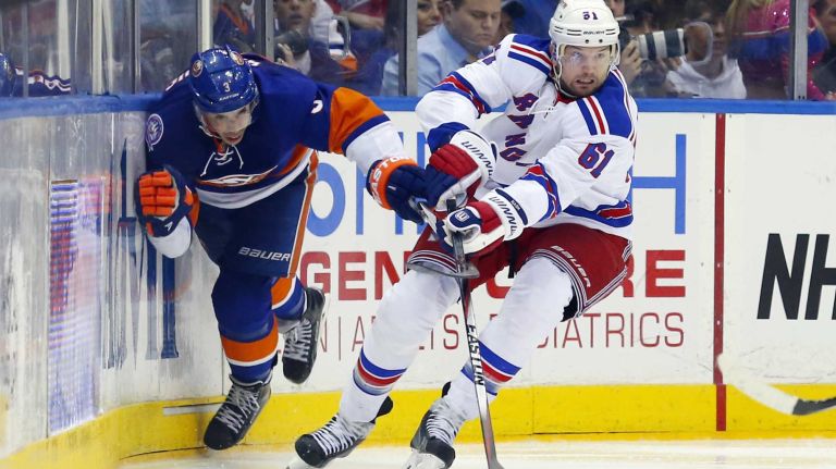 Rick Nash of the New York Rangers plays the puck in the third period against Travis Hamonic of the New York Islanders at Nassau Coliseum on Tuesday, March 10, 2015.