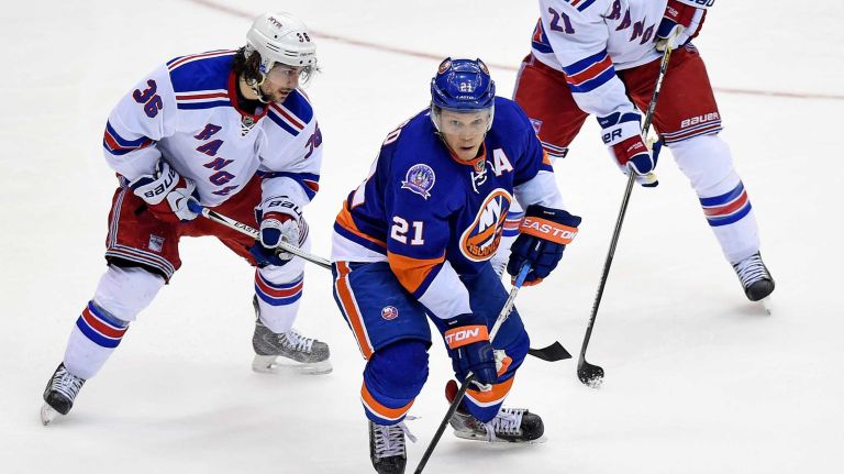 New York Islanders' Kyle Okposo moves the puck through New York Rangers' Mats Zuccarello and Derek Stepan in the third period at Nassau Coliseum on Tuesday, March 10, 2015.