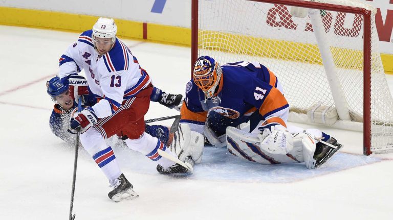New York Rangers' Kevin Hayes scores the tying goal against New York Islanders goalie Jaroslav Halak and defenseman Thomas Hickey in the second period at Nassau Coliseum on Tuesday, March 10, 2015.