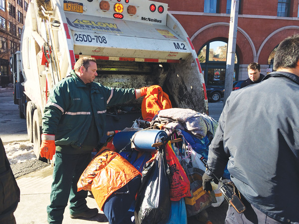 A sanitation worker got ready to toss Katsuyuki’s possessions into a garbage truck’s trash compactor on Feb. 11.
