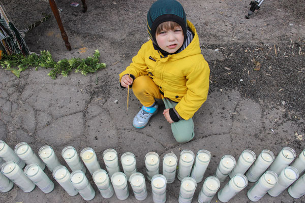 A young boy helped light some of the 105 memorial candles, one for each year of the church’s existence.