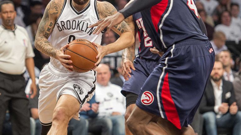The Brooklyn Nets' Deron Williams drives to the basket against Paul Millsap and Kent Bazemore of the Atlanta Hawks in the third quarter of Game 4 of the first round of the NBA playoffs at the Barclays Center on Monday, April 27, 2015.