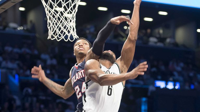 The Brooklyn Nets' Alan Anderson lays the ball up for two while the Atlanta Hawks' Kent Bazemore fouls him on the play in the third quarter of Game 4 of the first round of the NBA playoffs at the Barclays Center on Monday, April 27, 2015.