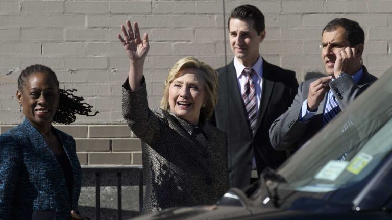 Former Secretary of State Hillary Rodham Clinton waives to a pedestrian after announcing the 
