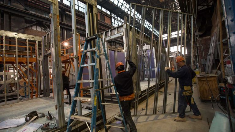 Carpenters installing an already framed wall to one of the modules by Capsys Corp., a modular manufacturer, at the Brooklyn Navy Yard, April 9, 2015, part of New York City's micro apartment project. Once completed, the apartments will be moved to Manhattan later date. April 9, 2015.