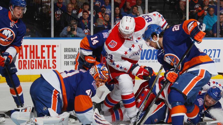 Jay Beagle #83 of the Washington Capitals looks for the rebound as the puck bounces off the leg pad of Jaroslav Halak #41 of the New York Islanders during the first period in Game 3 of the Eastern Conference quarterfinals during the 2015 NHL Stanley Cup playoffs at the Nassau Veterans Memorial Coliseum on April 19, 2015.