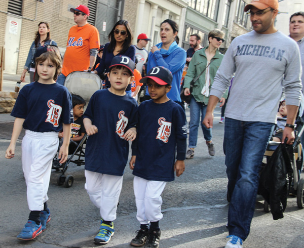Downtown Express photos by Tequila Minsky The Downtown Little League parade April 18. Adam Fritz on stilts, below left. Players enjoyed the sounds of the TriBattery Pops marching band before the games began,.