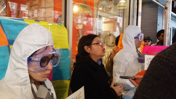 Councilmember Rosie Mendez, center, spoke at an April 20 press conference flanked by hazmat suit-wearing Mahfar tenants.   Photo by Angee Cortorreal