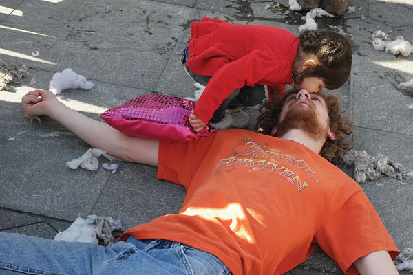 A little girl gave a worn-out pugilist a kiss amid the pillow carnage at last year's International Pillow Fight Day in Washington Square Park. The event's critics say if the event had a permit, it would ensure the organizers cleaned up afterward. But the organizers say the city will never give them a permit anyway.