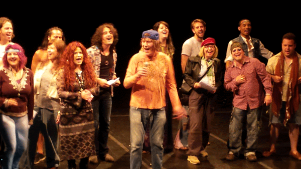 Things got “Hair”-y when James Rado, in orange shirt and cap, center, and flower children took the stage at the L.E.S. Festival of the Arts.   Photo by Scoopy