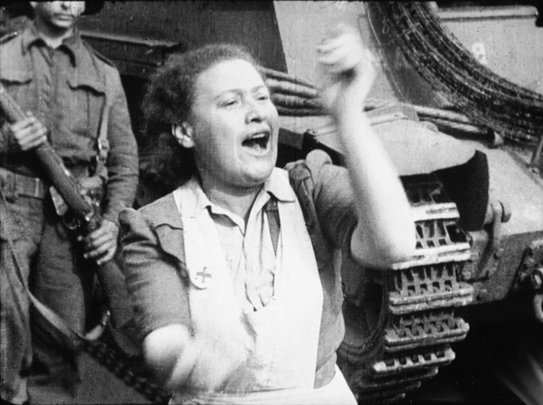 “Ex-prisoner claps her approval of strictness shown by Tommies,” another still by Sergent Lewis, April 16, 1945, from the documentary, showing the liberation of Bergen-Belsen by the British.