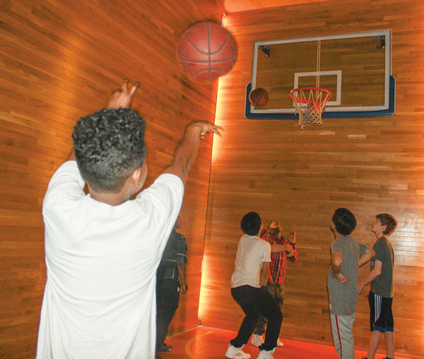 Local youths who are being helped by the initiative shot hoops on the former NBA great’s restaurant mini-court.