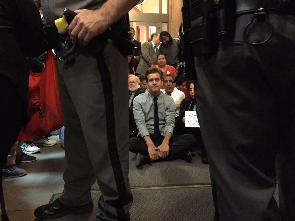 Hoylman, Assemblymember Richard Gottfried, to the left of him, and state Senator Adriano Espaillat, to his right, as they waited to be arrested while doing civil disobedience on Wednesday.