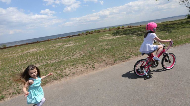 Sofia Zavaglia , 3, runs after her sister, Olivia, 6, riding her bike in Wolfe's Pond Park in Prince's Bay, Staten Island, Friday, May 22, 2015.