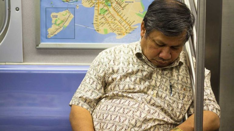 Man asleep on the subway amny