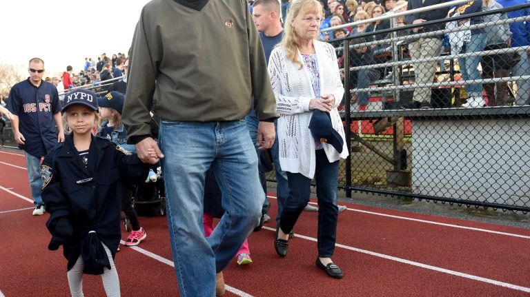 Family of slain NYPD Police Officer Brian Moore gather at a memorial service for him on the football field of Plainedge High School on Monday, May 4, 2015.