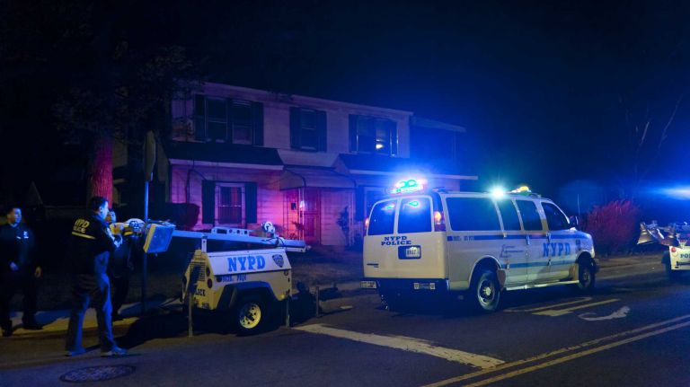 NYPD officers gather in a show of support near the location on 212th Street in Queens Village where a fellow officer was wounded after being shot by a man that police say he and his partner had wanted to question. Officers set up lights to search for the shooter near homes and darkened alleys.