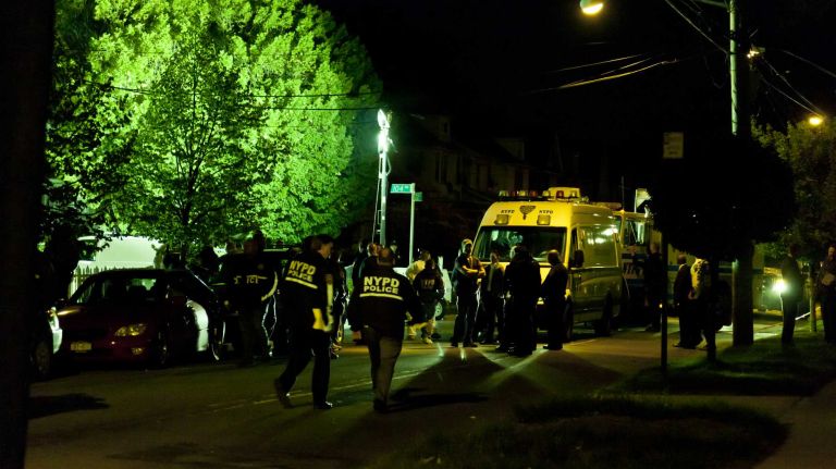NYPD officers gather in a show of support near the location on 212th Street in Queens Village where a fellow officer was wounded after being shot by a man, police said, he and his partner sought to question. Officers and detectives searched the area for the shooter. NYPD officers set up lights to search near homes and darkened alleys.