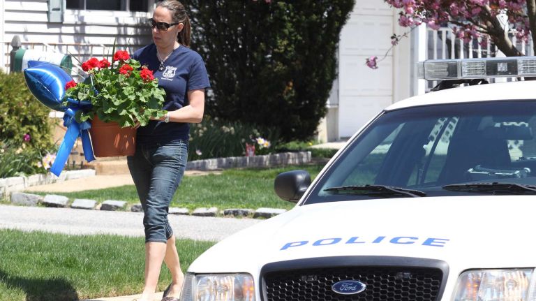 A friend leaves flowers at the home of NYPD Officer Brian Moore on Monday, May 4, 2015.