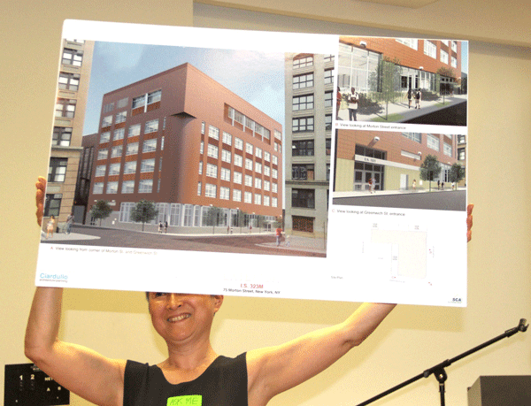 Downtown Express photo by Tequila Minsky Shino Tanikawa held up a design rendering of the exterior of 75 Morton St., showing how its windows will be enlarged.