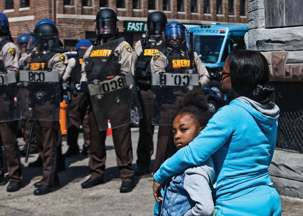 A pair of Baltimore residents found themselves confronted by a line of riot police during the unrest after Freddie Gray’s death.   Photos by Byron Smith