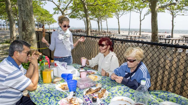 Anya, center, resident at Bay Park, Brooklyn, enjoys with their family members and neighbors at Manhattan Beach Park on June 8, 2015. ?By Yeong-Ung Yang