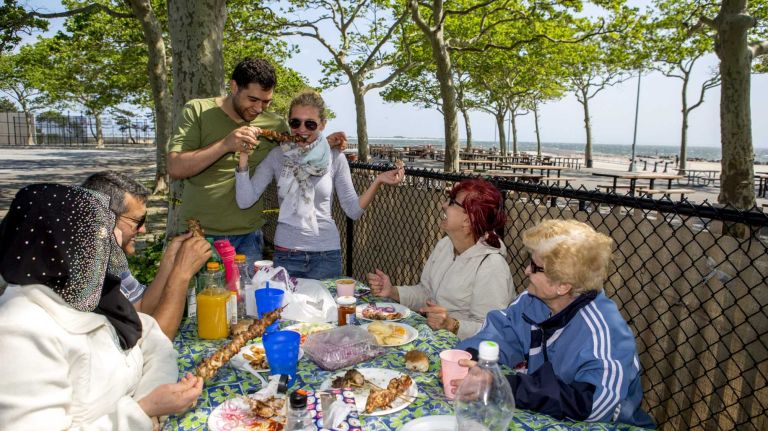 Bakhtiyor and Anya, center, residents at Bay Park, Brooklyn, enjoys with their family members and neighbors at Manhattan Beach Park on June 8, 2015. ?By Yeong-Ung Yang