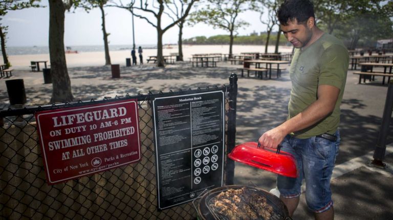Bakhtiyor, resident at Bay Park, Brooklyn, grills chicken for his family at Manhattan Beach Park on June 8, 2015. ?By Yeong-Ung Yang
